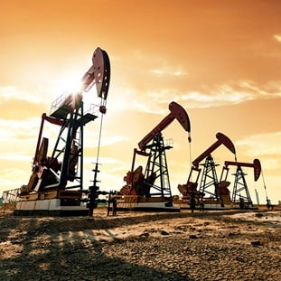 four oil pumps operating under sunrise sky